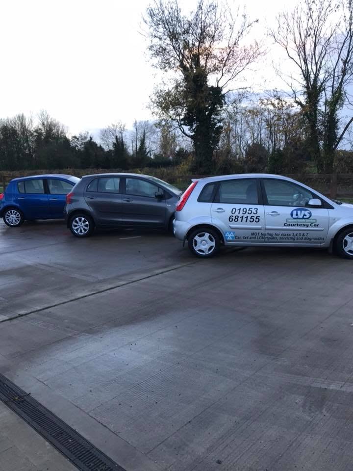 A silver Ford Fiesta courtesy car in Lopham Vehicle Services livery, parked in the yard