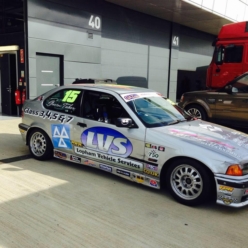 A silver BMW race car in Lopham Vehicle Services livery